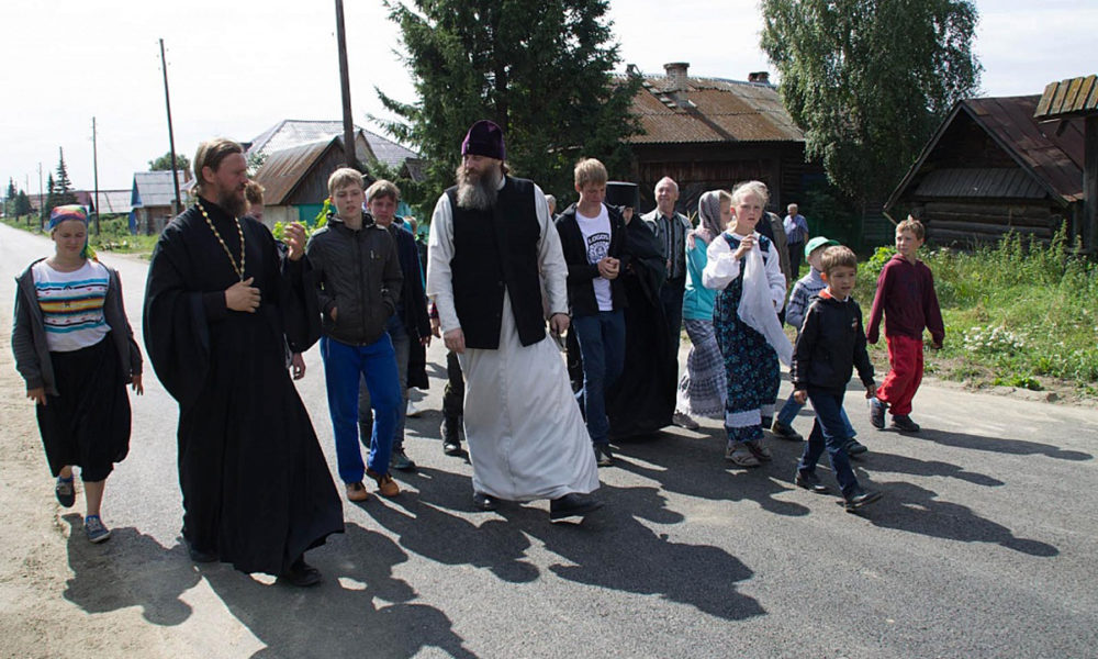 Митрополит Никодим на улице села Булзи в окружении детей и местного священнослужителя