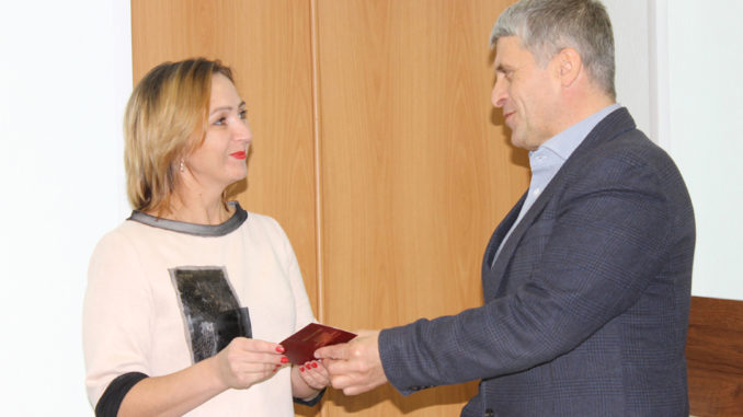 Галина Леонова получает значок и удостоверение из рук главы Игоря Колышева
