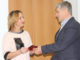 Галина Леонова получает значок и удостоверение из рук главы Игоря Колышева