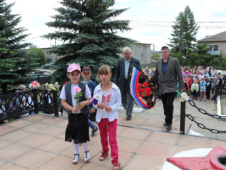 Иван Васильевич Гончаров и Малик Камильевич Сагдеев вместе с юными тюбукчанами возлагают венок и цветы к памятнику