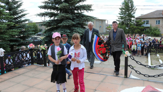 Иван Васильевич Гончаров и Малик Камильевич Сагдеев вместе с юными тюбукчанами возлагают венок и цветы к памятнику